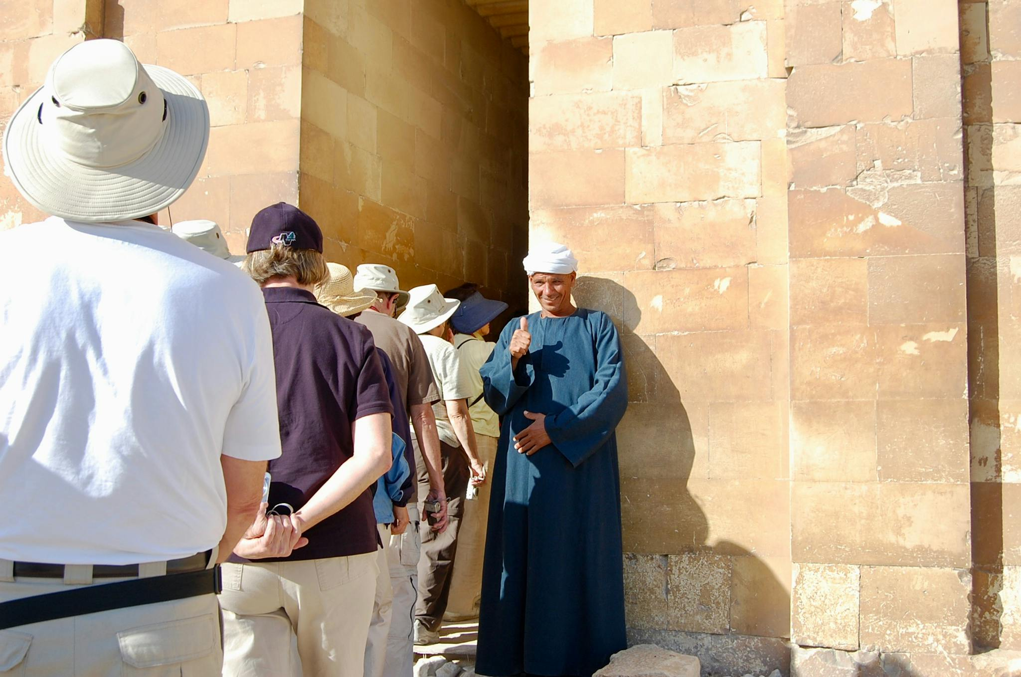 A local guide gives a thumbs up to tourists at a historic site in Cairo, Egypt.