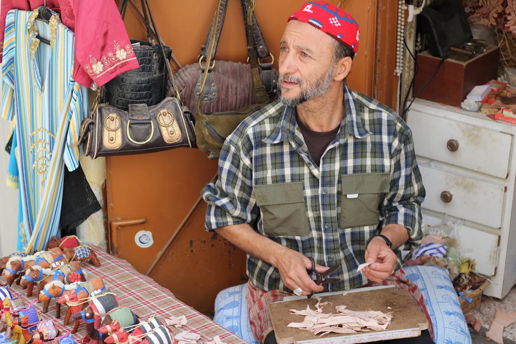 A skilled artisan crafting goods at a market stall in Tangier, Morocco.