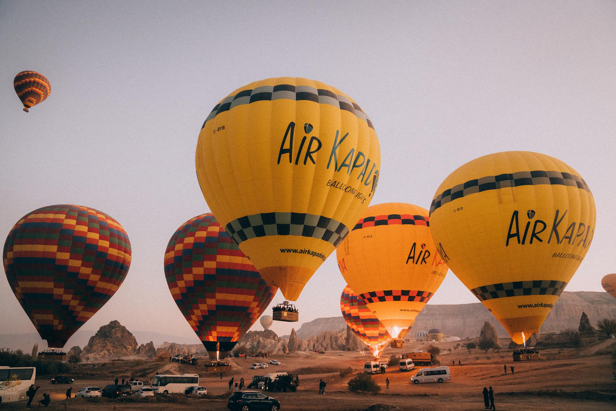 Colorful hot air balloons soaring at sunrise over the unique rock formations of Cappadocia.
